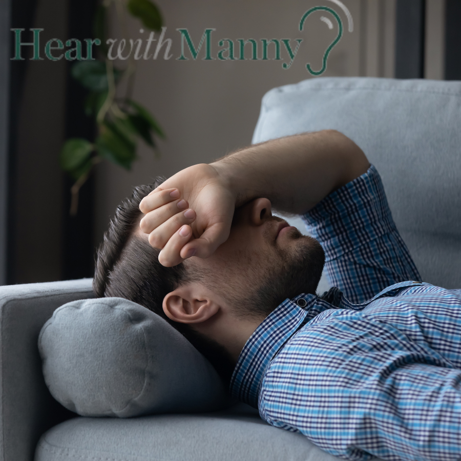 Man on couch with his arm over his eyes.