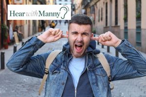 man plugging his ears in pain